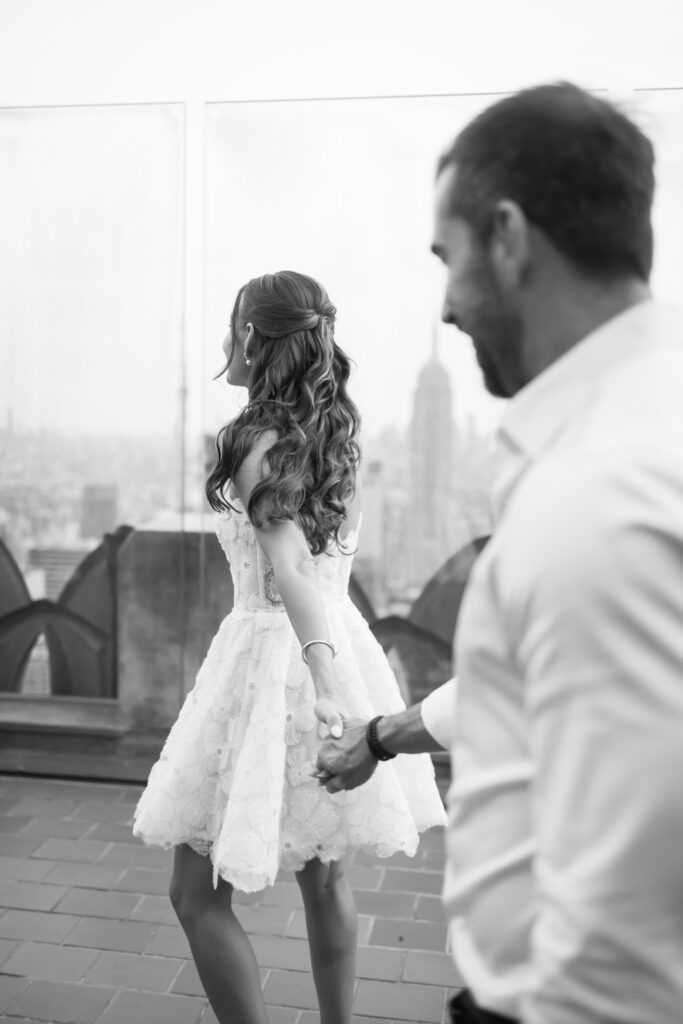 Olya and Felipe walk hand-in-hand through the crowd, lost in each other as the sunset creates a romantic glow.